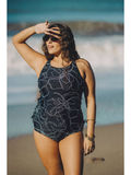 Woman wearing Maya Tankini Swim Top With Removable Cups | Plus Size in a floral print at the beach, showcasing size-inclusive, modest swimwear with a supportive and comfortable fit. Swimwear designed for every body.