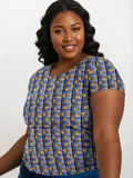 Woman wearing a blue and yellow patterned top on a white background