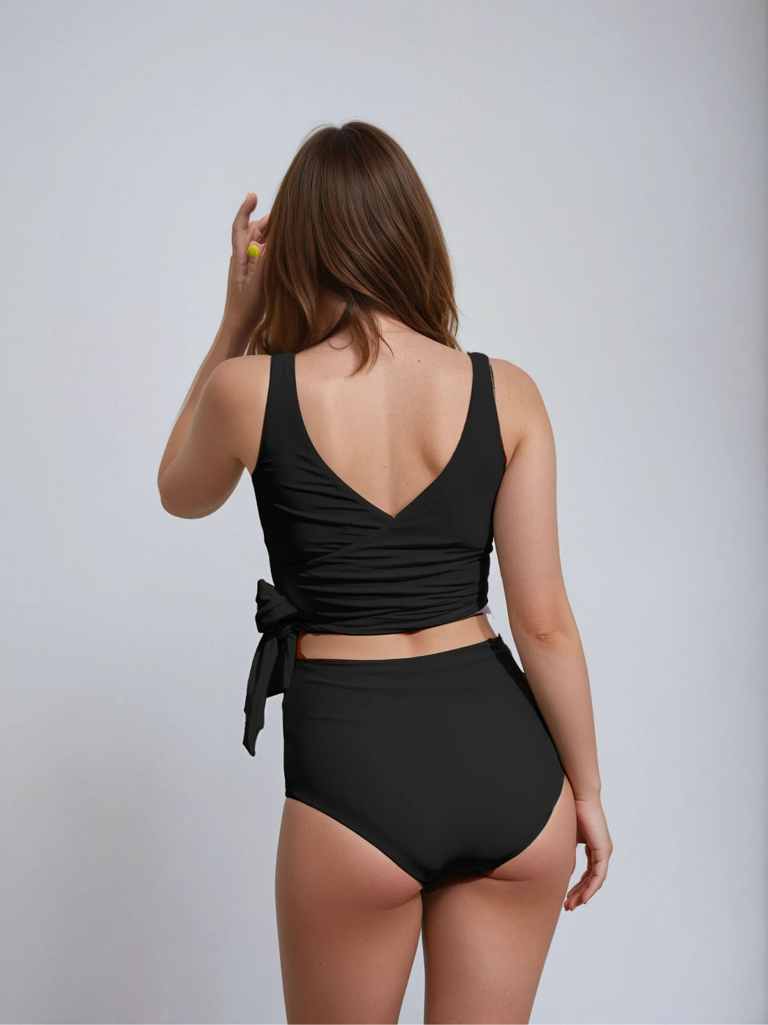 Woman wearing a black bikini against a plain background