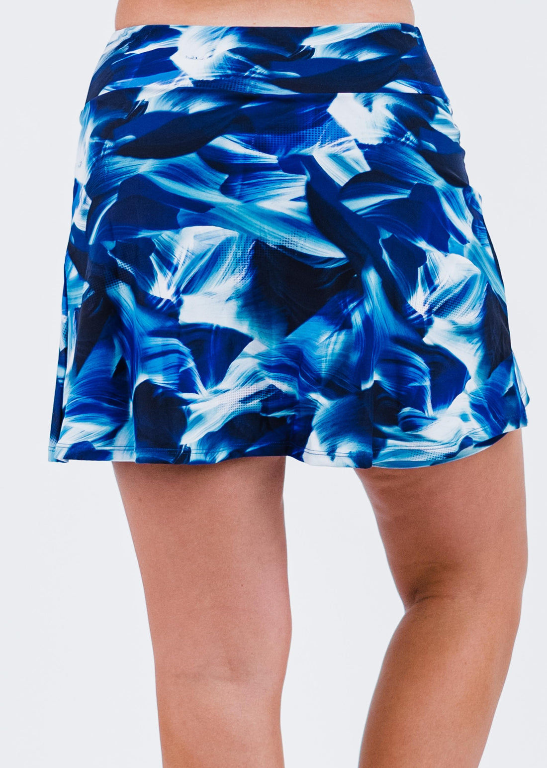 Blue abstract patterned skirt worn by a person on a white background