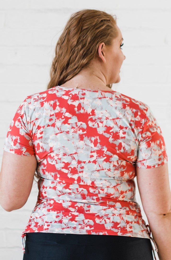 Person wearing a red and white patterned shirt against a white background