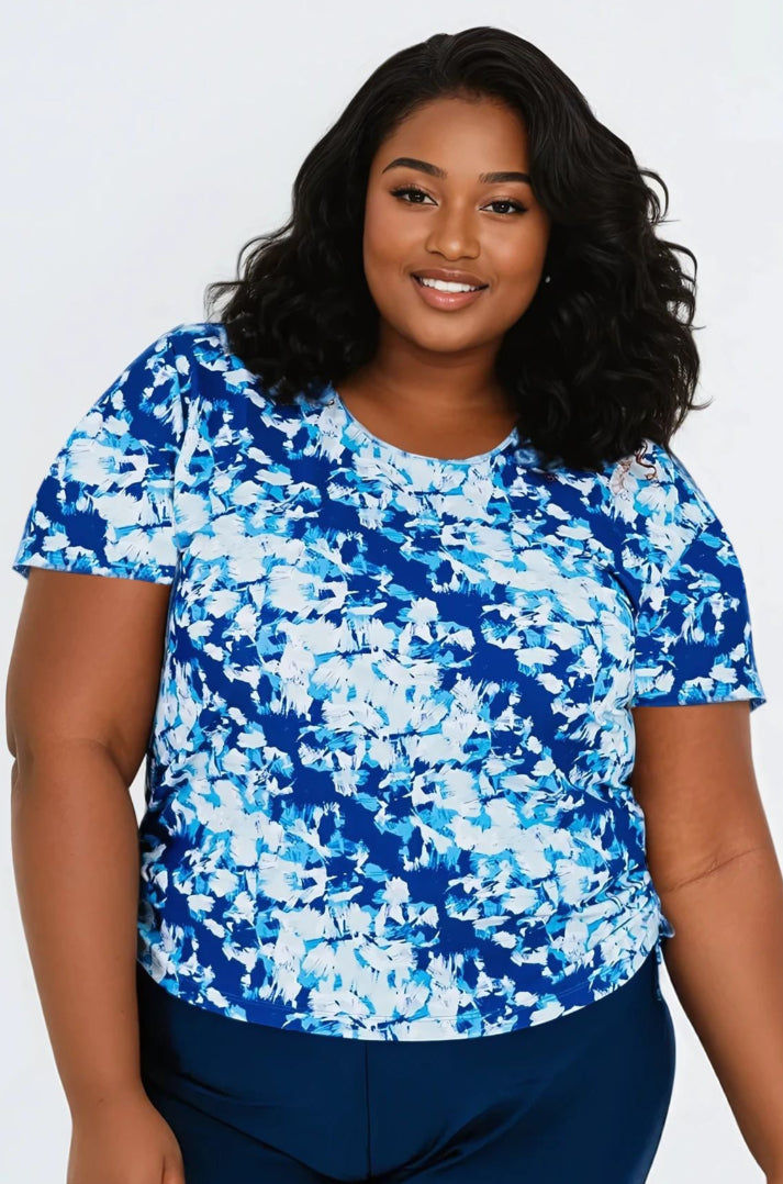Woman wearing a blue and white patterned shirt against a plain background