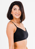 Woman wearing a black sports bra against a white background