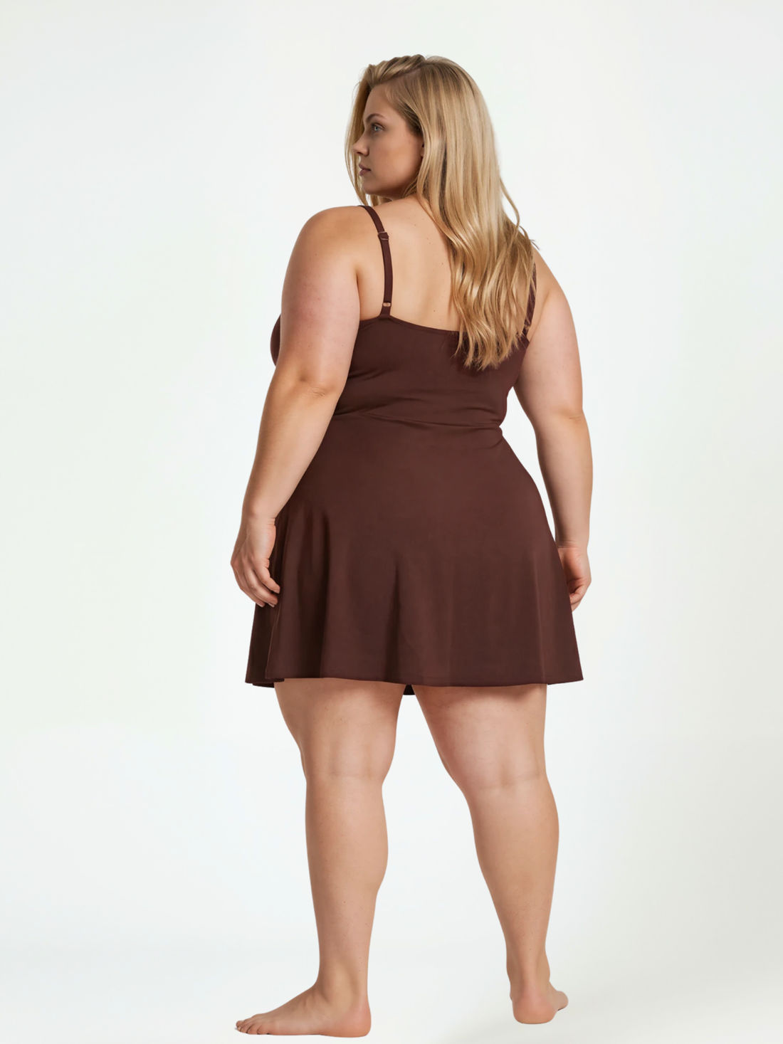 Woman standing on the beach wearing a black and white floral Alana Swim Dress | Plus Size, showcasing size-inclusive, modest swimwear with a comfortable fit and supportive design. Swimwear designed for every body.