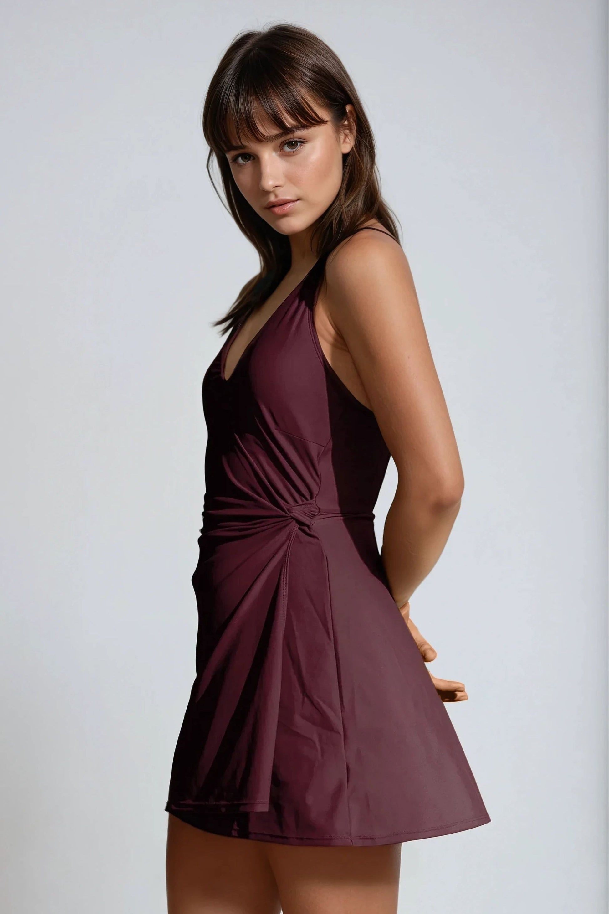 Woman wearing a burgundy dress against a plain background