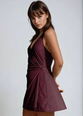 Woman wearing a burgundy dress against a plain background