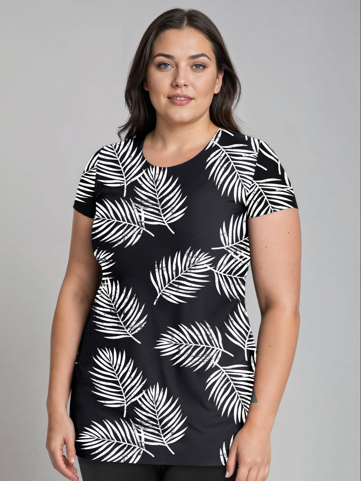 A model wearing a navy blue and green floral Anna Longer Length Swim Tunic with short sleeves and a round neckline.