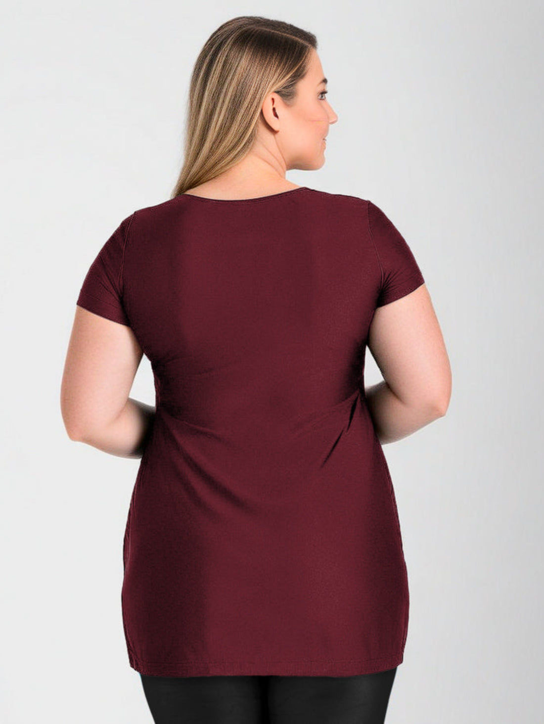 Woman wearing a maroon t-shirt against a gray background