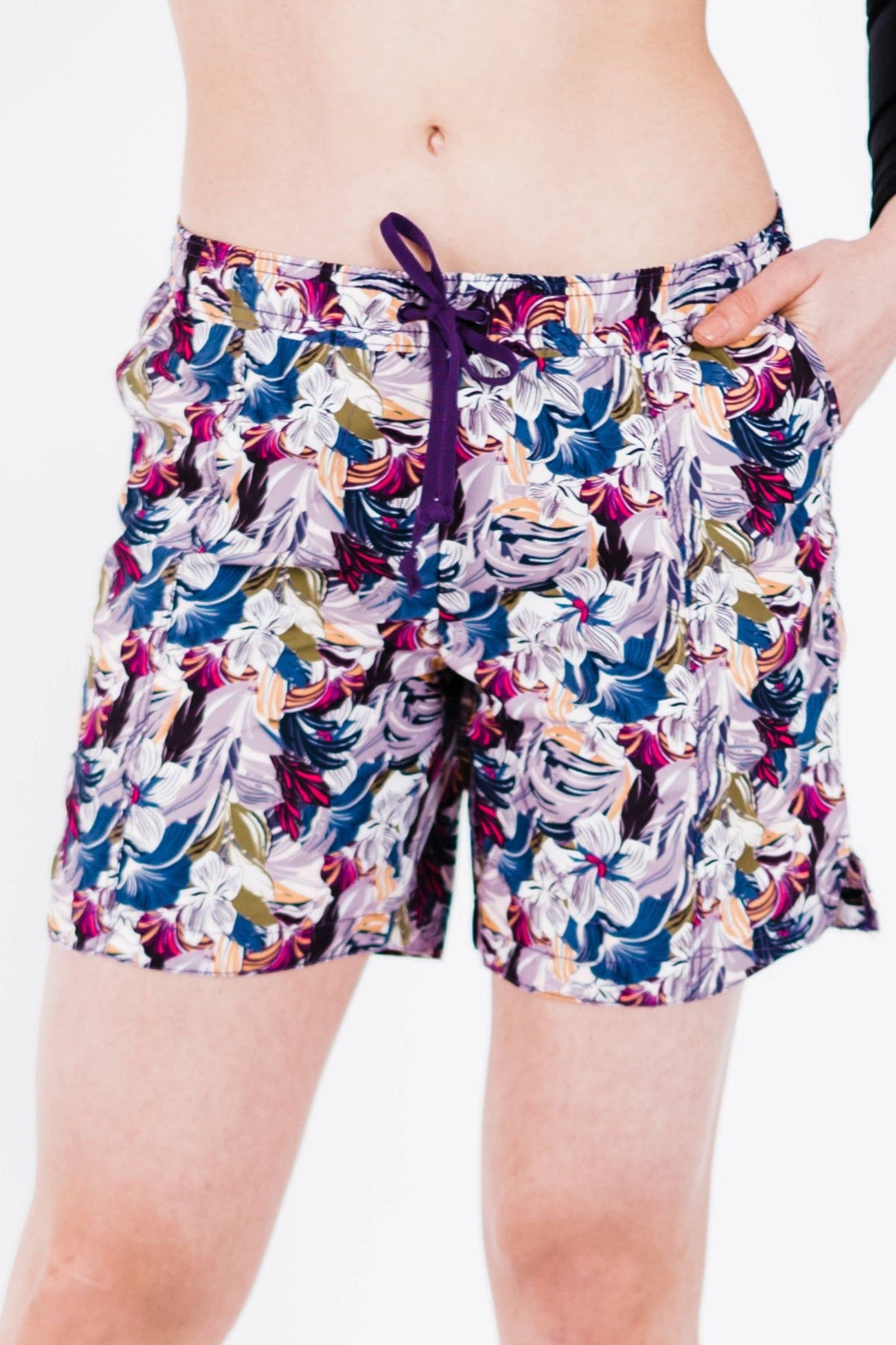 Colorful floral-patterned shorts worn by a person on a white background