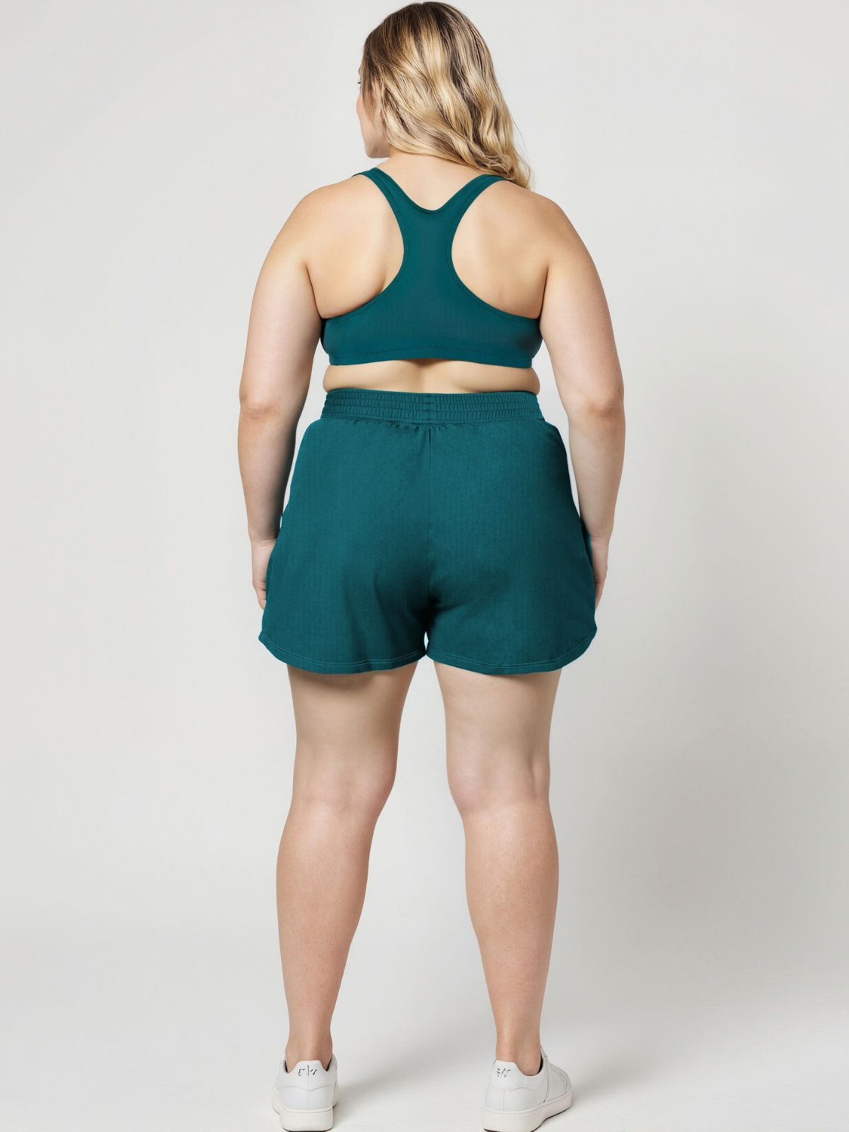 Back view of a plus size model wearing teal Classic Fit Swim Shorts With Panty | Plus Size with a supportive racerback top for comfortable size inclusive swimwear designed for every body