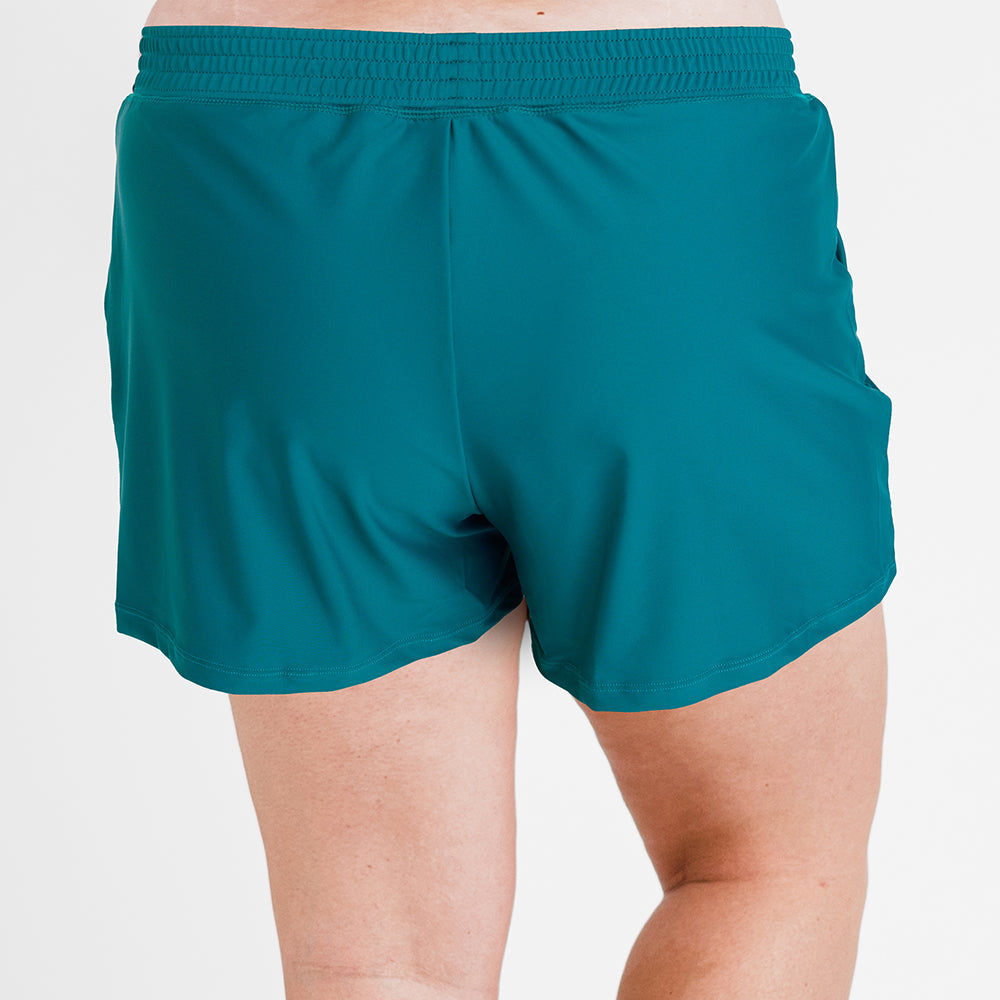 Back view of a person wearing Classic Fit Swim Shorts With Panty | Final Sale in dark jade, showcasing a comfortable fit designed for modest, supportive, size-inclusive swimwear, swimwear designed for every body.