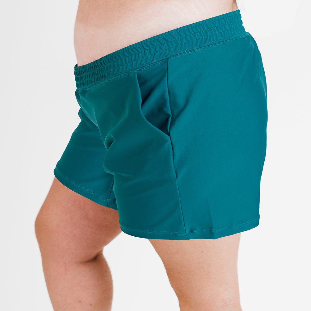 Side view of plus size swimwear in dark jade color, featuring Classic Fit Swim Shorts With Panty | Final Sale, designed for a comfortable fit with size-inclusive, modest, and supportive swimwear for every body.