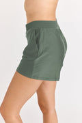Green athletic shorts worn by a person on a light gray background