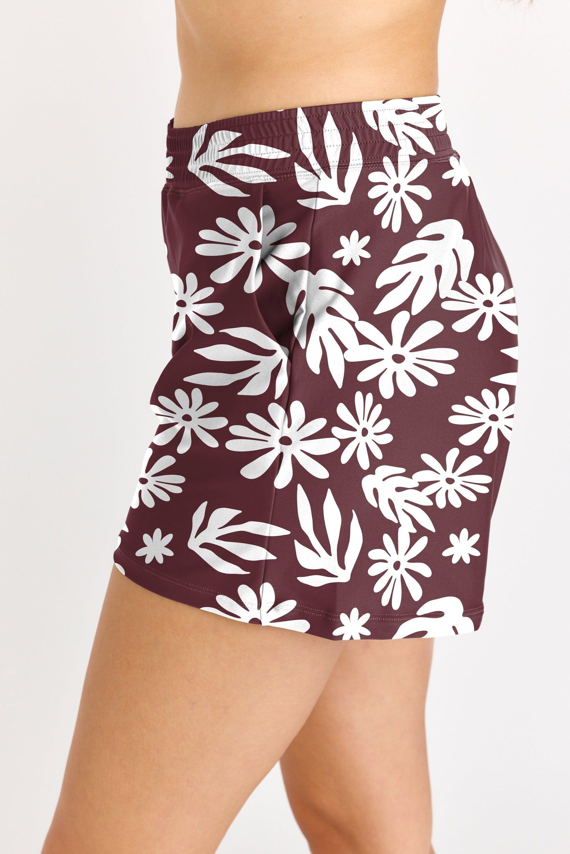 Maroon skirt with white floral pattern worn by a person on a plain background