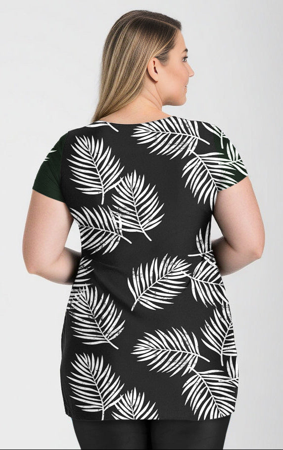 A model wearing a navy blue and green floral Anna Longer Length Swim Tunic with short sleeves and a round neckline.