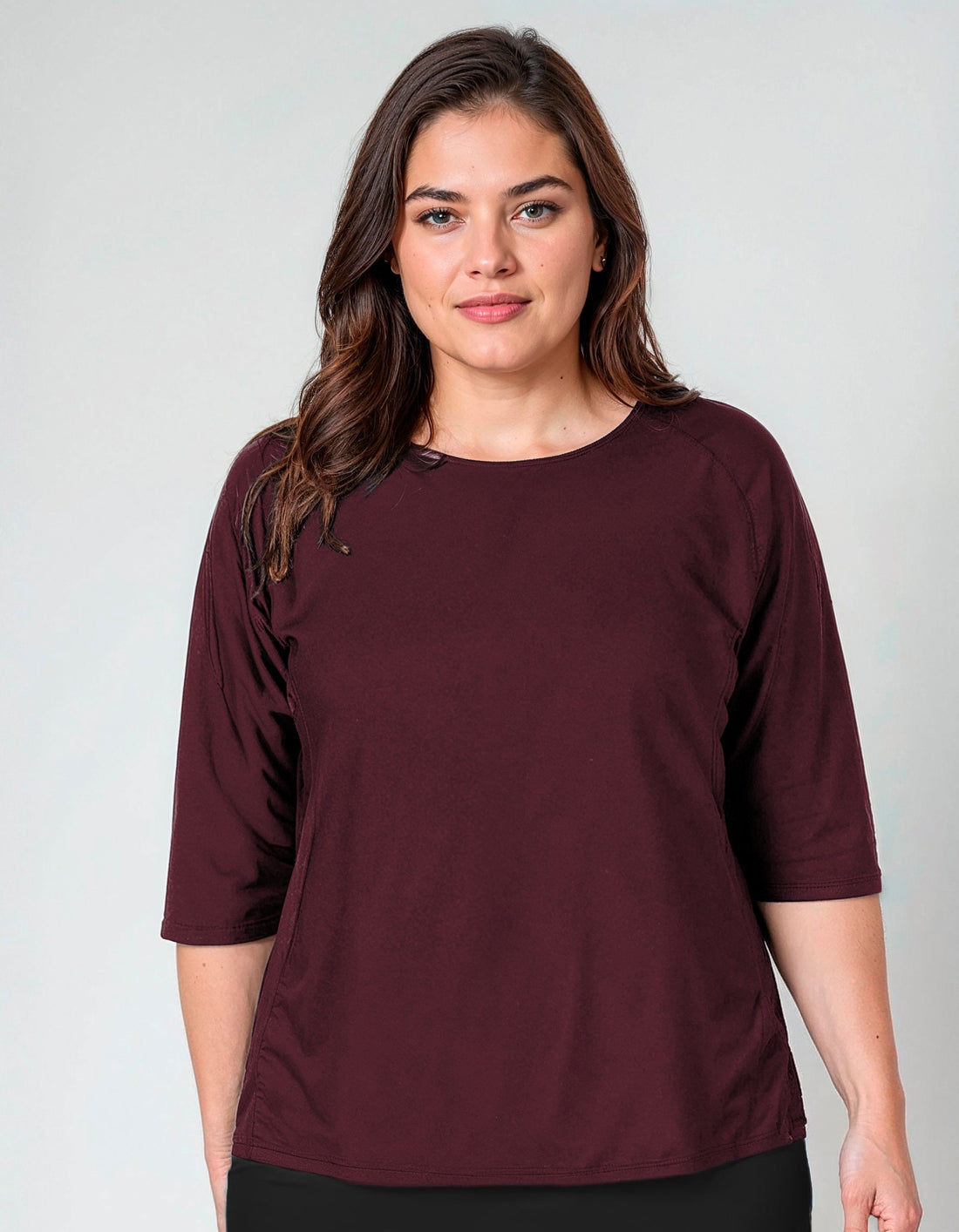 Woman wearing a navy blue outfit with floral sleeves on a plain background