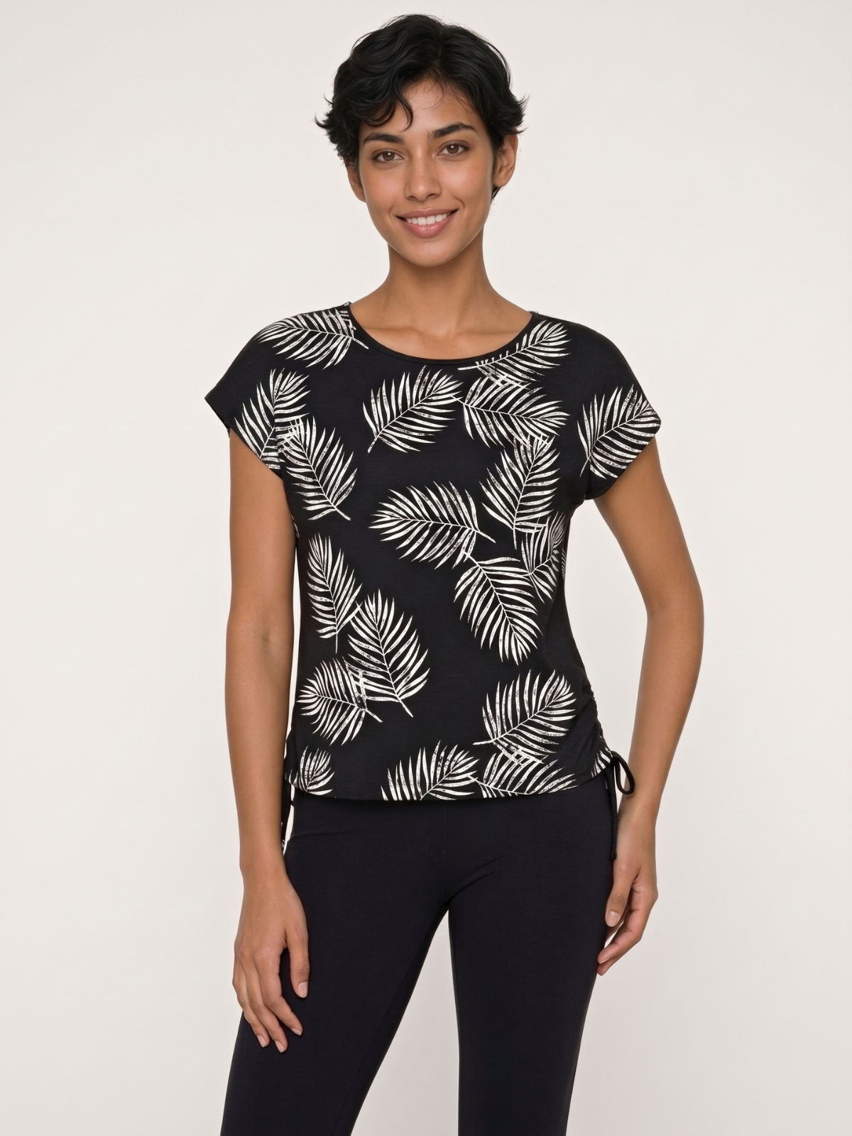 Daphne Loose Fit Swim Top in black with a white leaf print and short sleeves styled with black swim leggings for comfortable swimwear for women
