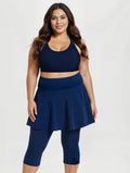 Model wearing Flared Swim Skort With Capri Leggings | Plus Size in navy with a fitted tank top and white sneakers showcasing supportive swimwear designed for every body.