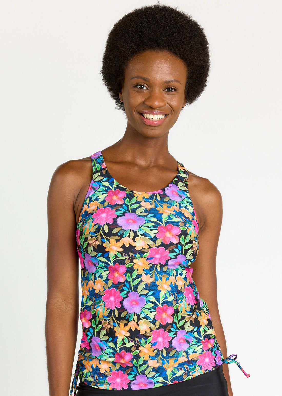 Woman wearing a yellow floral tank top against a white background