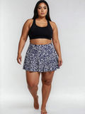 Model wearing Flowy Swim Skort With Shorts | Plus Size in a navy floral print with built-in shorts and a black swim top for modest supportive swimwear designed for every body