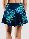 Navy blue skirt with green floral pattern worn by a person on a white background
