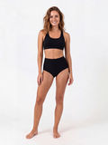 High Waisted Full Coverage Bikini Bottom in black modeled by a woman offering supportive comfortable coverage and size inclusive swimwear designed for every body