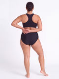 High Waisted Full Coverage Bikini Bottom | Plus Size shown from the back on a model in black swimwear offering supportive comfort and size inclusive coverage