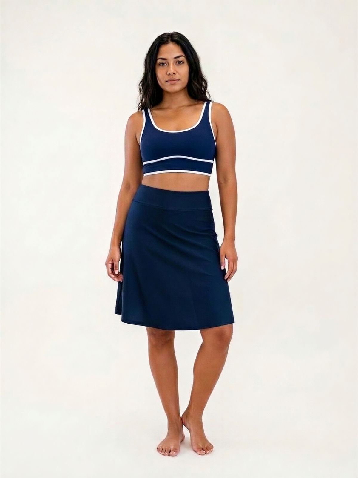 Woman wearing navy Knee Length Swim Skort With Bike Shorts and a matching supportive swim top for a comfortable fit and modest swimwear designed for every body