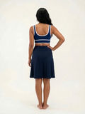 Knee Length Swim Skort With Bike Shorts shown from the back on a woman in navy swimwear with a knee length skirt and built in shorts for a comfortable fit