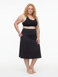 Plus size model wearing black Long Swim Skort With Capri Leggings | Plus Size swimwear with modest coverage and a comfortable supportive fit