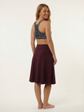 Long Swim Skort With Capri Leggings shown from the back on a smiling model wearing a burgundy skirt and patterned black swim top for modest swimwear