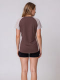 Loose Fit Adele Swim Top shown from the back with striped short sleeves and side panels paired with black swim shorts for supportive comfortable swimwear designed for every body
