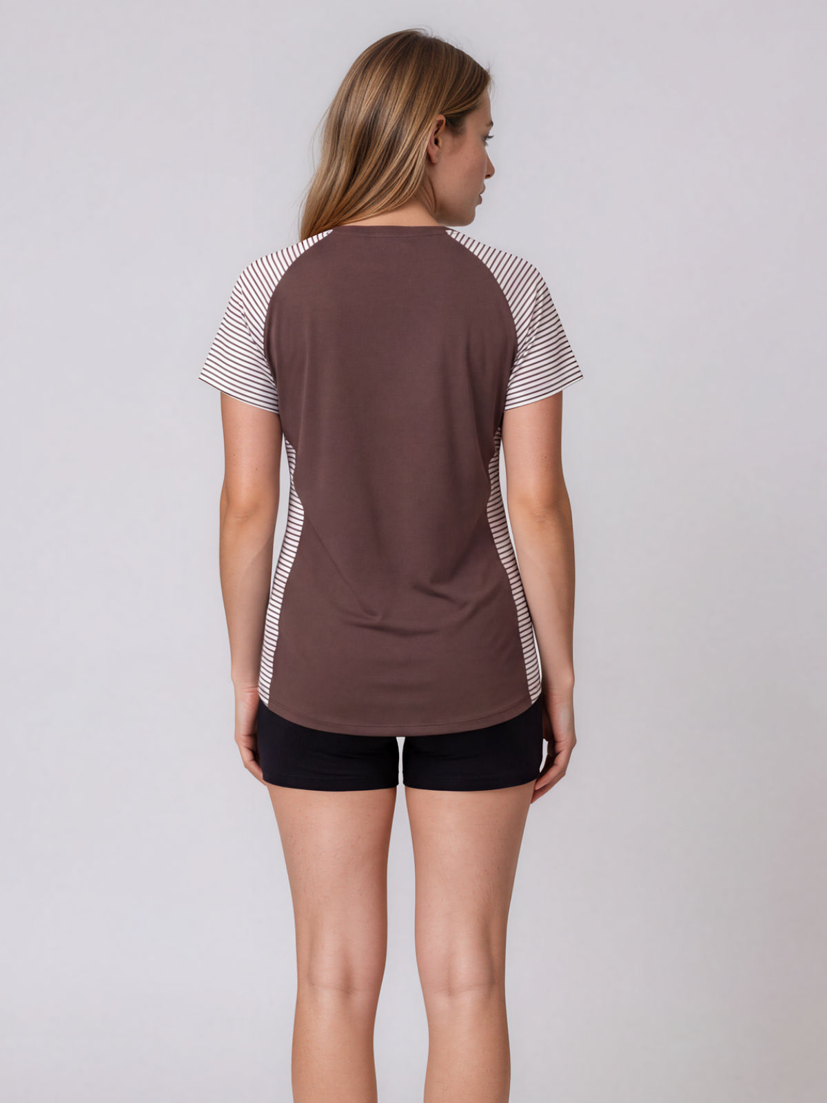 Loose Fit Adele Swim Top shown from the back with striped short sleeves and side panels paired with black swim shorts for supportive comfortable swimwear designed for every body