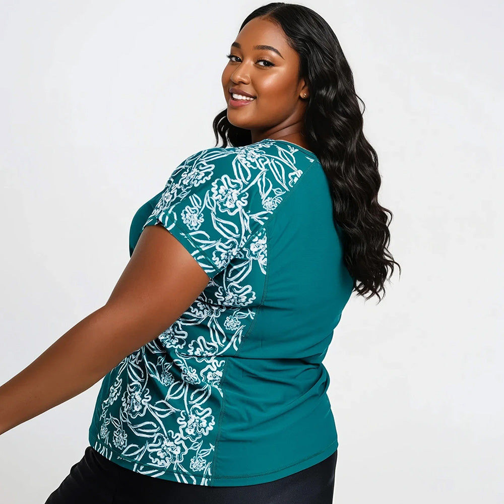 Plus size woman modeling the Loose Fit Adele Swim Top | Final Sale in dark jade with floral pattern, showcasing size-inclusive, supportive, and comfortable swimwear designed for every body.