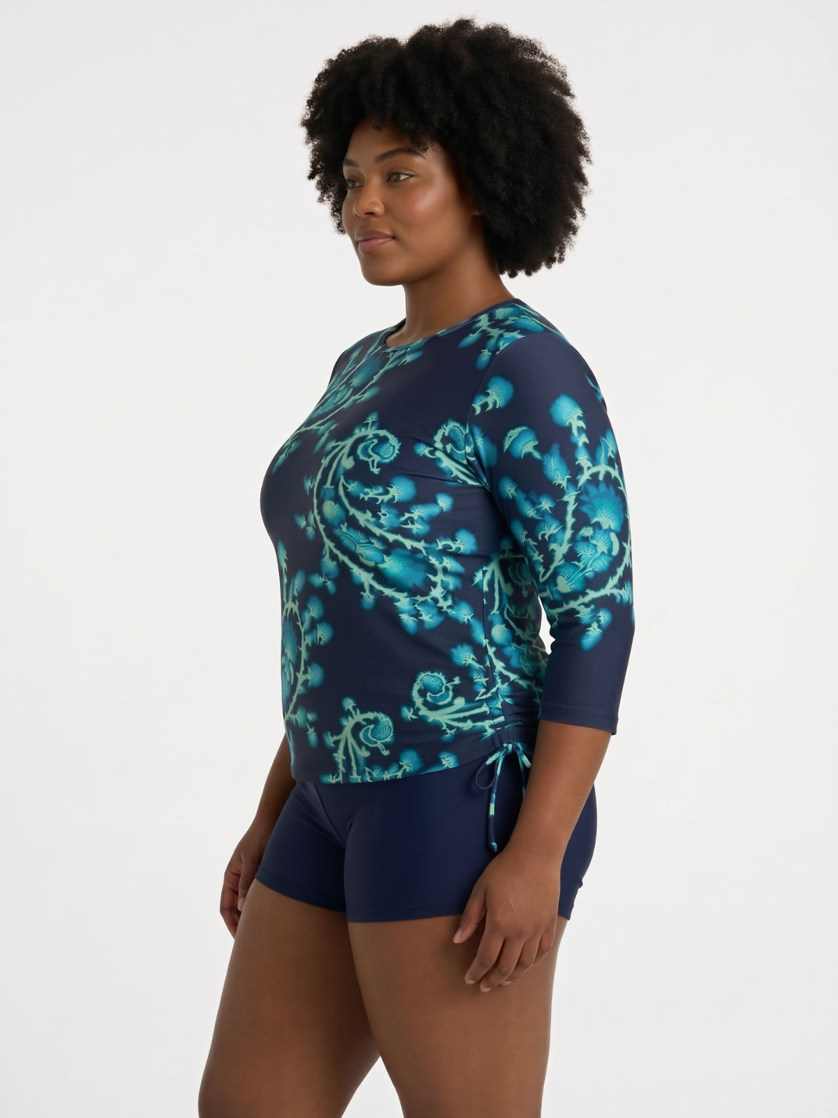 Margaux Swim Top | Plus Size modeled by a woman in a navy floral swim top with elbow length sleeves and swim shorts for comfortable size inclusive swimwear