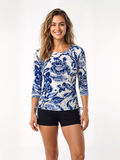 Margaux Swim Top in a blue and white floral print worn by a smiling woman with black swim shorts for supportive comfortable swimwear designed for every body