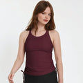 Woman modeling a supportive and comfortable wine-colored Maya Tankini Swim Top With Built-in Bra | Last Call, showcasing size-inclusive swimwear designed for every body.