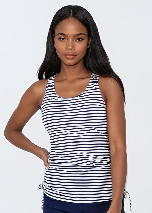 Woman wearing a black and white striped tank top against a plain background