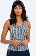Woman wearing a blue patterned tank top against a white background