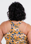 Person wearing a yellow floral dress with a white background