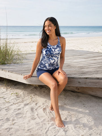 Maya Tankini Swim Top With Removable Cups in blue and white floral print worn by a woman at the beach with ocean views supportive comfortable swimwear for every body