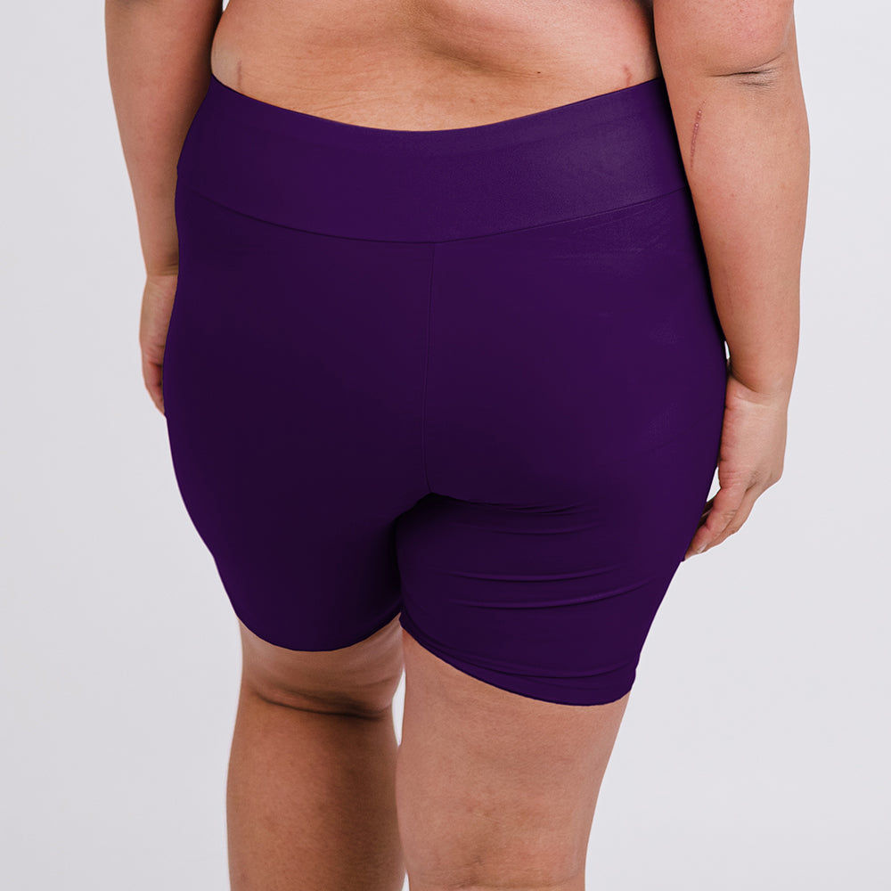 Back view of a model wearing purple Mid-Thigh Swim Shorts | Final Sale with a supportive comfortable fit and size-inclusive modest swimwear design
