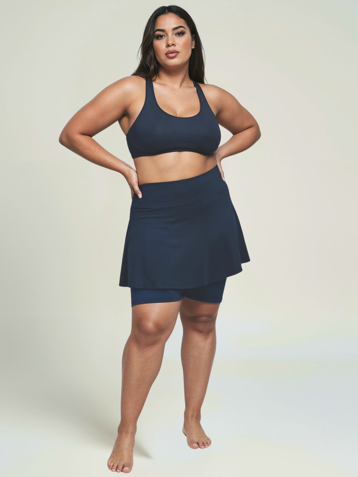 Woman wearing a navy blue athletic outfit on a plain background