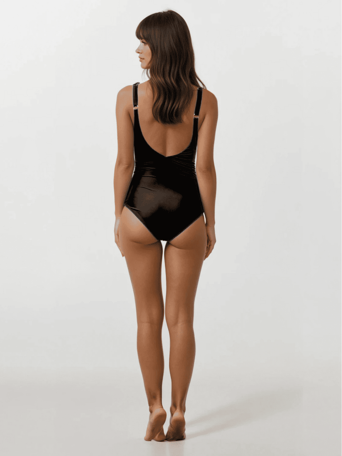Woman wearing a black swimsuit against a white background