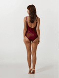 Woman wearing a burgundy swimsuit on a white background