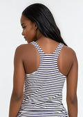 Woman wearing a black and white striped tank top against a plain background