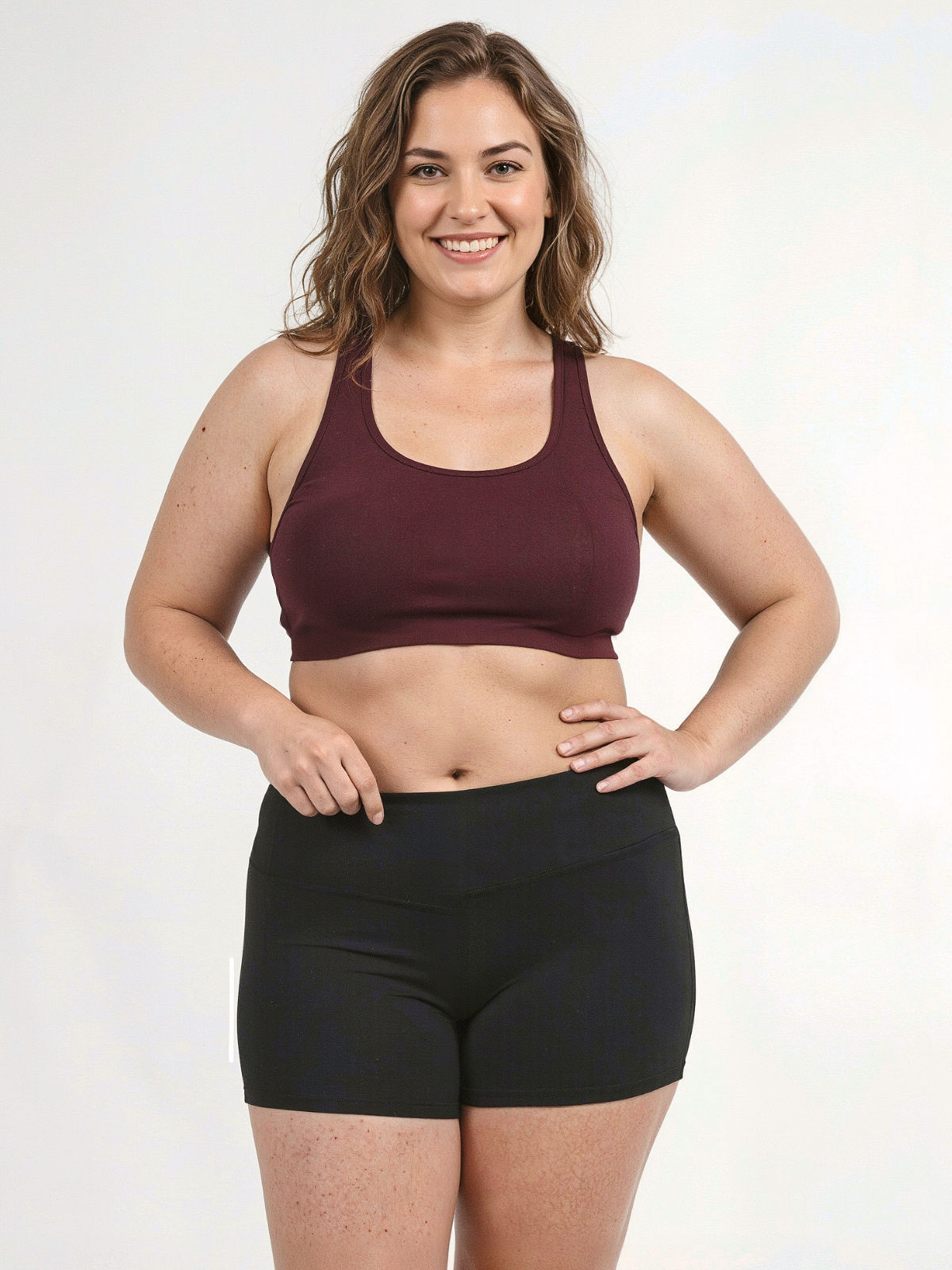 Racerback Swim Bra | Plus Size burgundy swim top styled with black swim shorts on a smiling model showcasing supportive comfortable swimwear designed for every body