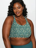 Woman wearing a green floral bikini top against a white background