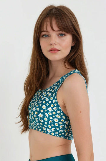 Woman wearing a green floral bikini top against a white background