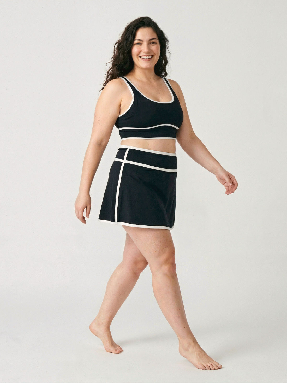 Short Swim Skort Two-Toned With Shorts | Plus Size modeled by a smiling woman beside a pool in coastal sunlight. Size-inclusive modest supportive swimwear with a comfortable fit.